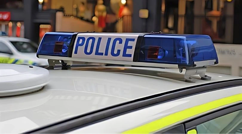 Close-up of UK police car roof with flashing blue lights, symbolising rapid response to vehicle theft alerts.